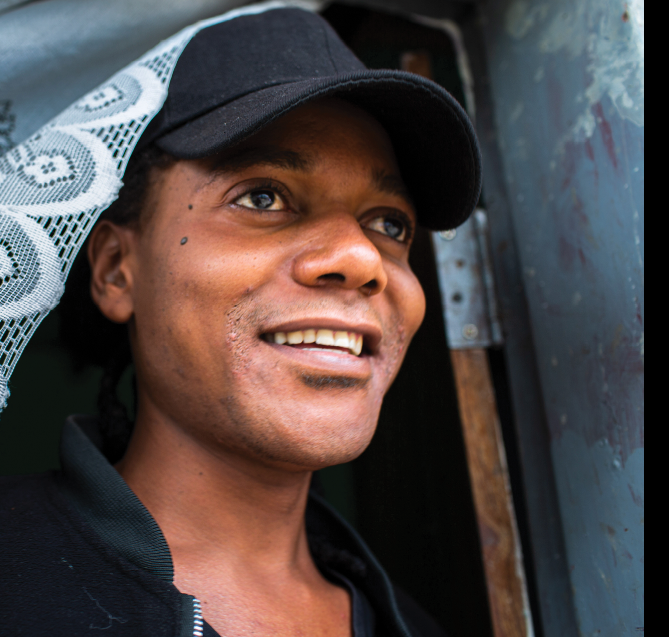 Jomell M’hango, a 28 year old DZL client, looks out the doorway in his house in John Laing Compound, Lusaka Zambia on 25 November 2020. Frontline AIDS, in partnership with the Elton John AIDS Foundation, has created a COVID-19 Emergency Fund, which enables healthcare workers from Dignitate Zambia’s (DZL), a Zambia-based community organisation, to offer mobile outreach care support to communities most affected by HIV. The mobile support entails HIV testing, food and grocery supplies, and counselling support for those struggling with the lockdown restrictions as well as survivors of gender-based and domestic violence.