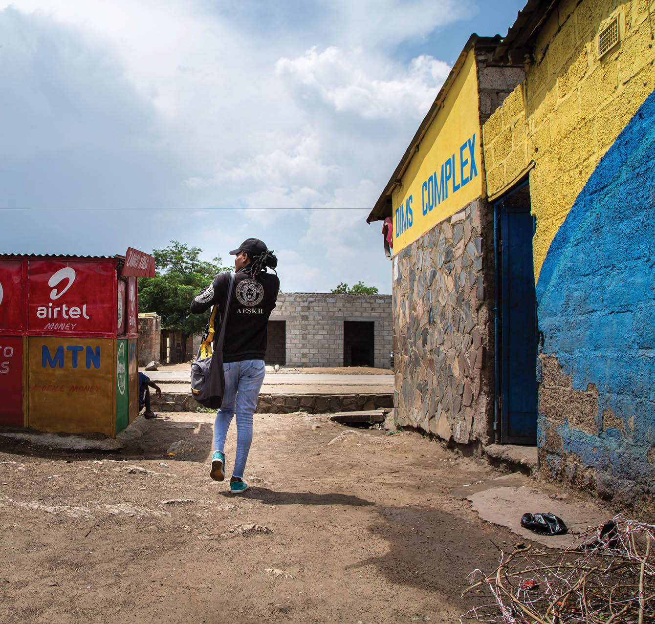 Jomell M’hango, a 28 year old DZL client, walks through his community in John Laing Compound, Lusaka Zambia,on 25 November 2020. Frontline AIDS, in partnership with the Elton John AIDS Foundation, has created a COVID-19 Emergency Fund, which enables healthcare workers from Dignitate Zambia’s (DZL), a Zambia-based community organisation, to offer mobile outreach care support to communities most affected by HIV. The mobile support entails HIV testing, food and grocery supplies, and counselling support for those struggling with the lockdown restrictions as well as survivors of gender-based and domestic violence.
