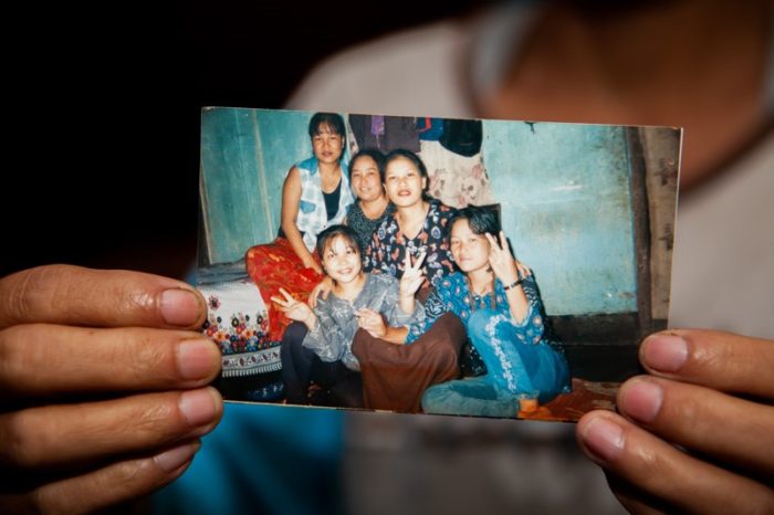 A lady holding a photo of family