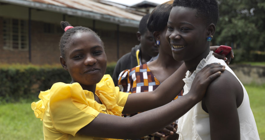 Two young Tanzanian women in yellow and white dresses