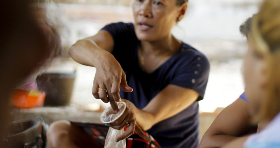 A woman demonstrates condoms Myanmar