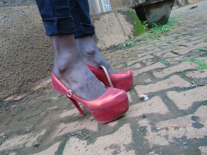 The red high heeled shoes worn by a sex worker.
