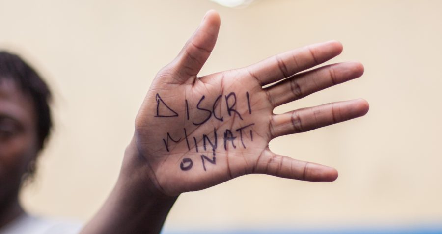 The word 'discrimination' written on someone's hand
