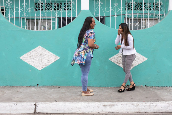 Two transgender women laugh and chat on the street