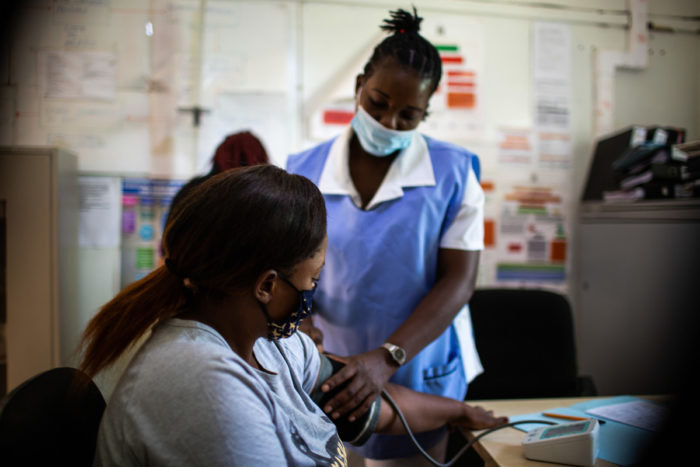A nurse taking a young woman's blood pressure
