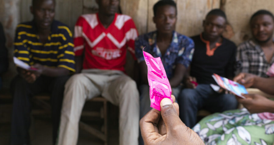 Young people watch a condom demonstration
