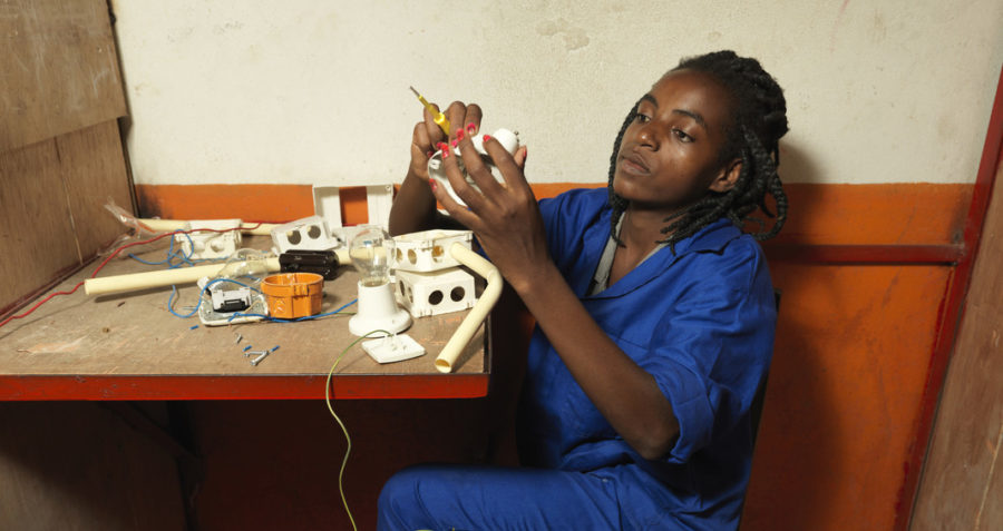 A young woman working on a project as part of her electrician training