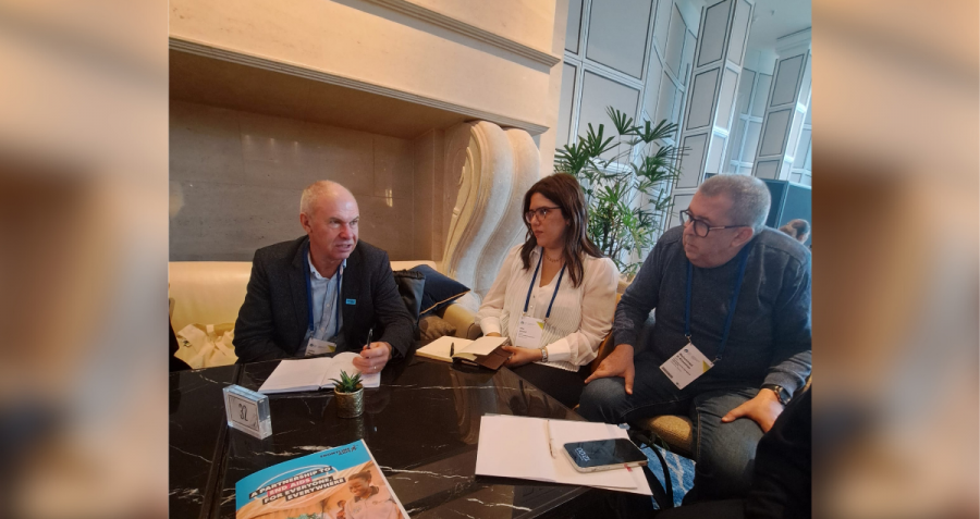 Three people sit on a sofa in a hotel lobby in Berlin, Germany