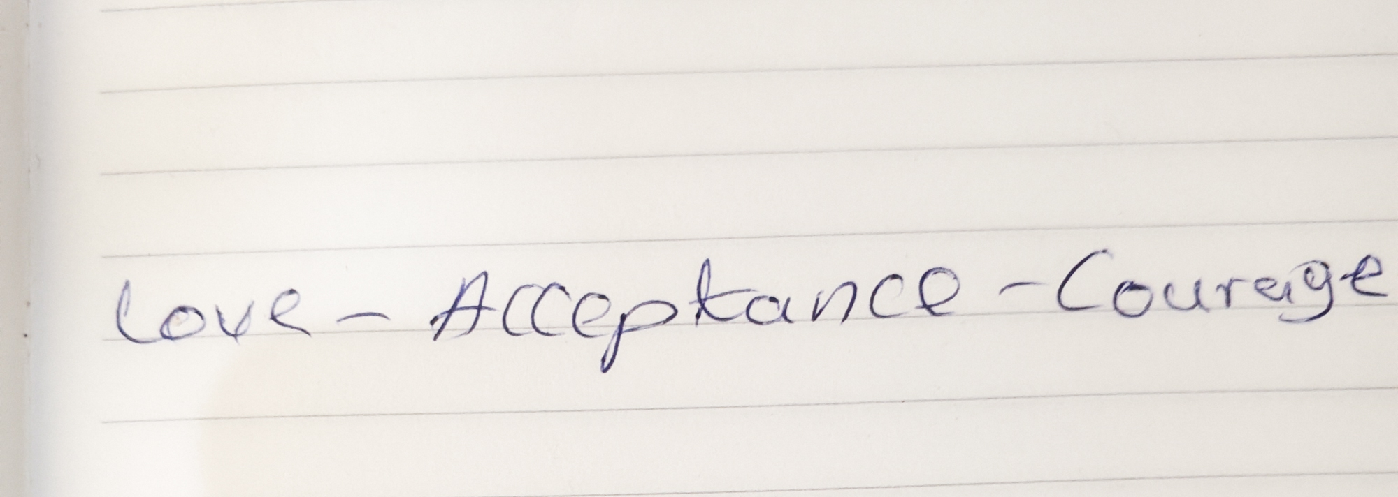 A handwritten note on a small piece of lined paper reads: Love-Acceptance-Courage