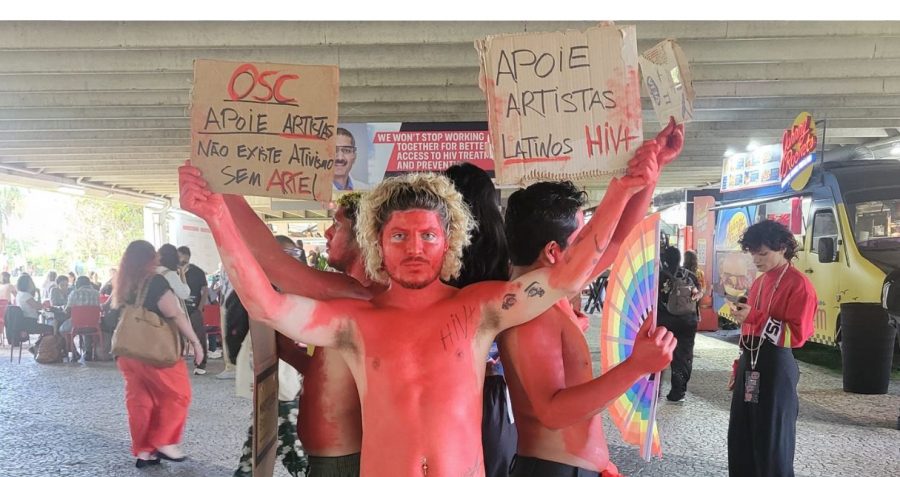 People painted red stand holding placards that say